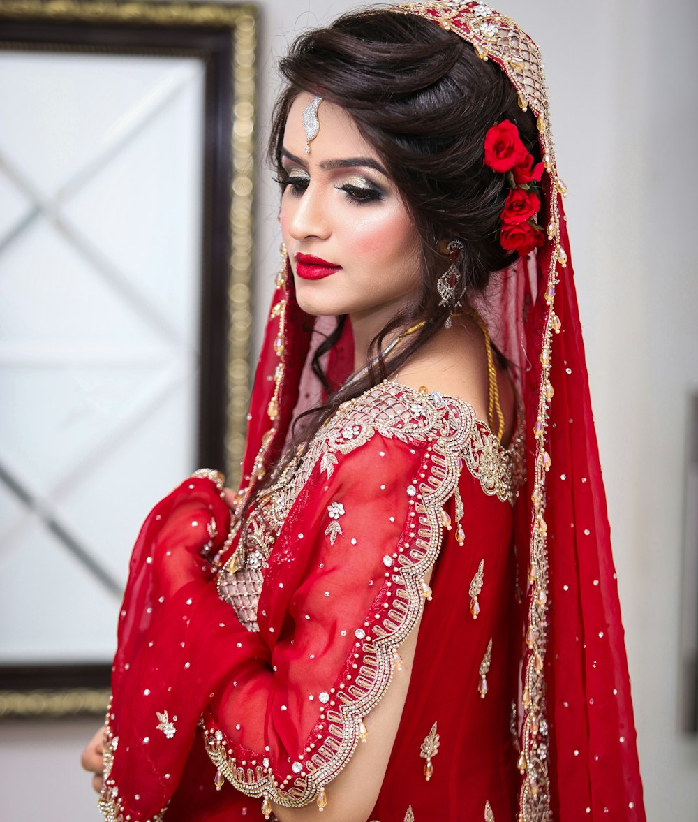 a woman in a red dress with a red rose in her hair