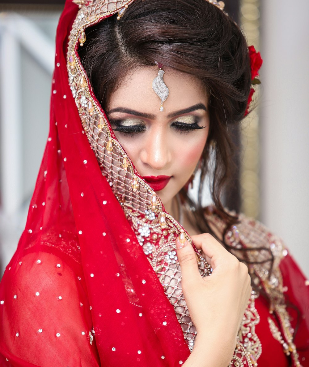 a woman in a red dress with a veil on her head