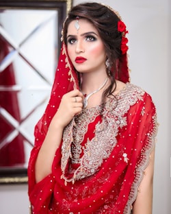 a woman in a red dress with a veil on her head