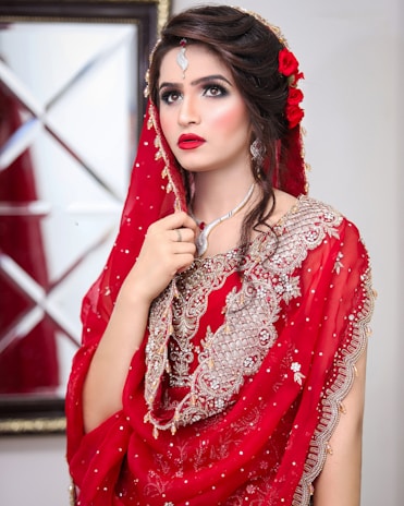 a woman in a red dress with a veil on her head