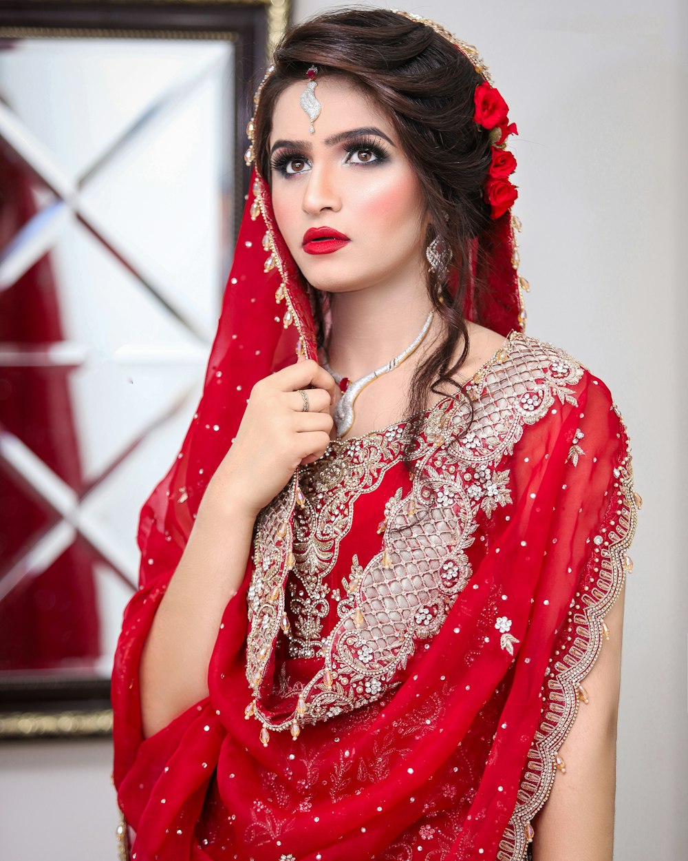 a woman in a red dress with a veil on her head