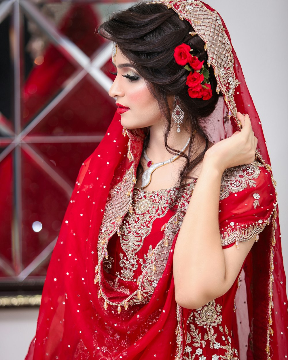 Une femme en robe de mariée rouge avec une rose rouge dans les cheveux