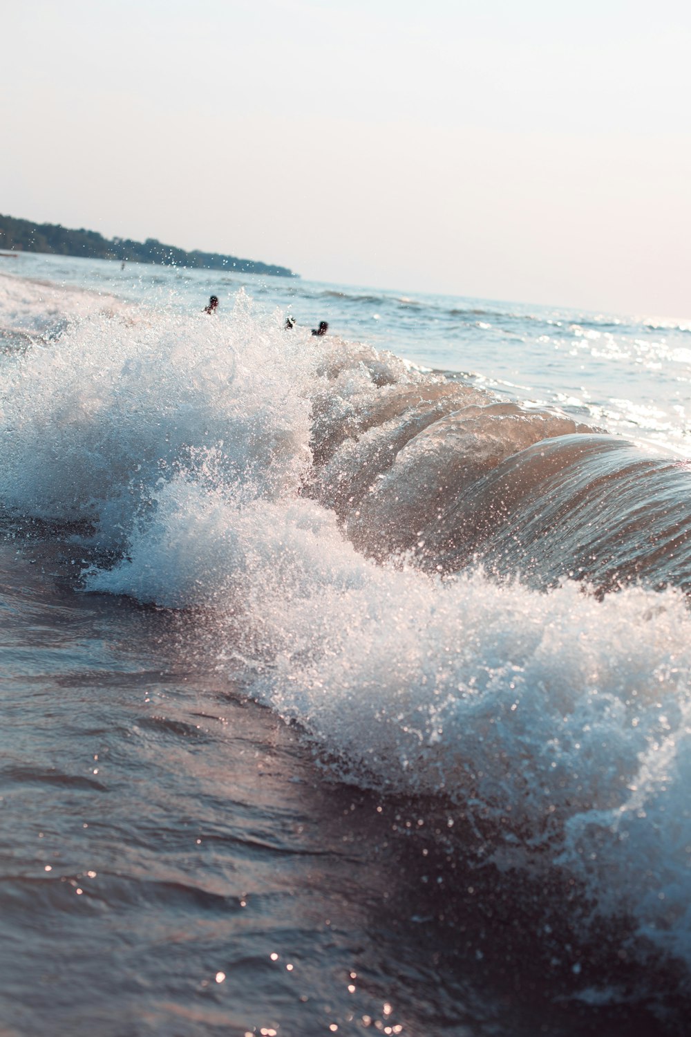 Eine große Welle, die gegen das Ufer eines Strandes prallt