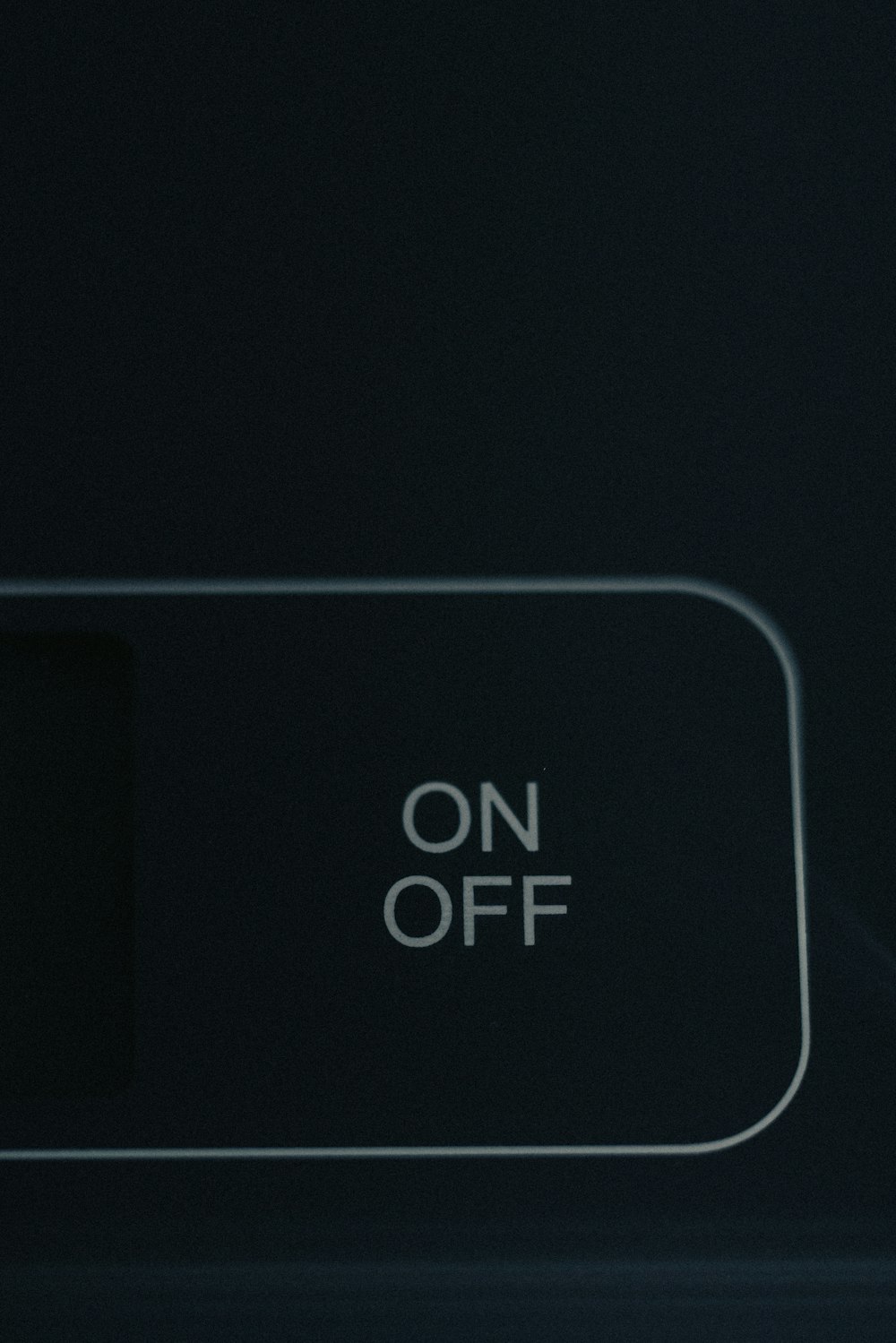 an on off button on a black wall
