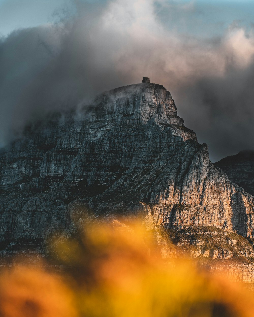 a very tall mountain with some clouds in the sky