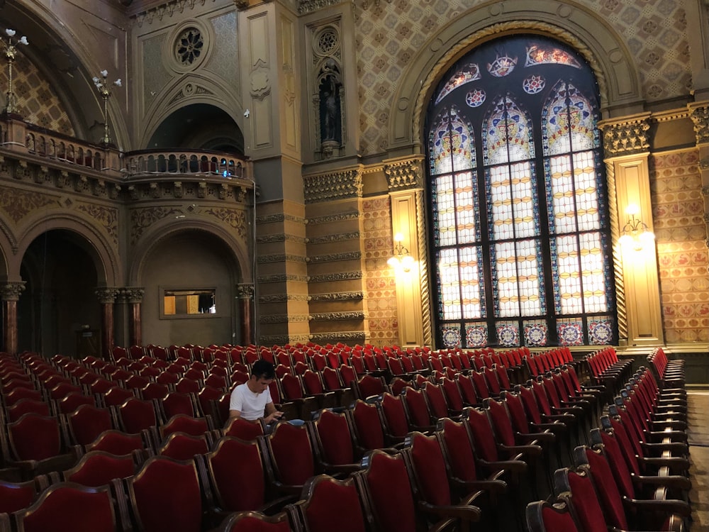 a large room with red chairs and a large window