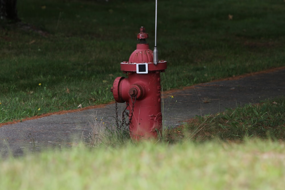 a red fire hydrant sitting on the side of a road