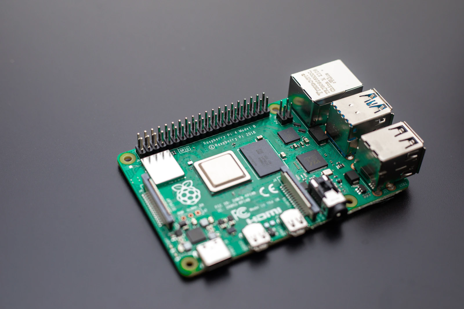 Raspberry Pi 4 Model B single-board computer with Gigabit Ethernet and USB ports on a dark desk