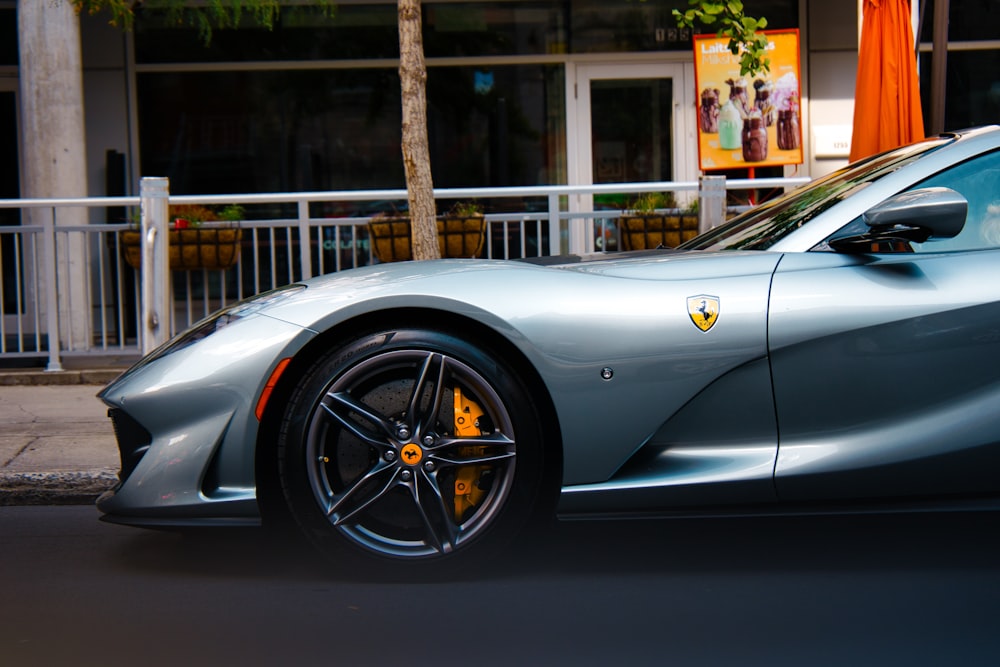 a silver sports car parked in front of a building