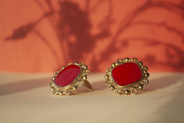 a pair of red earrings sitting on top of a table