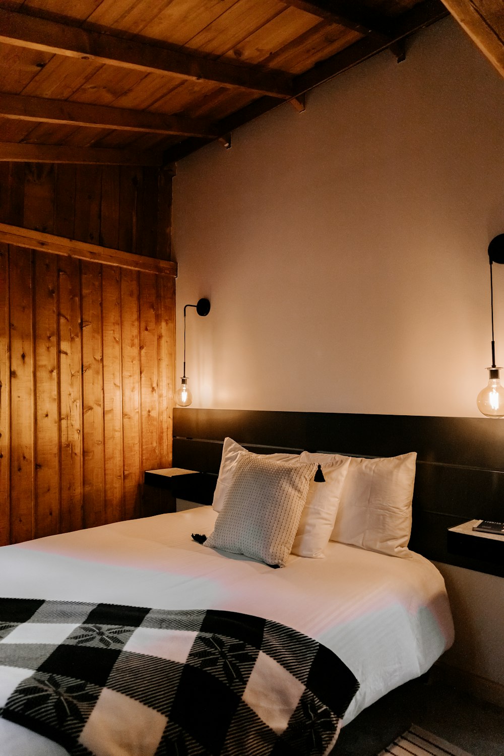 a bed sitting in a bedroom next to a wooden wall