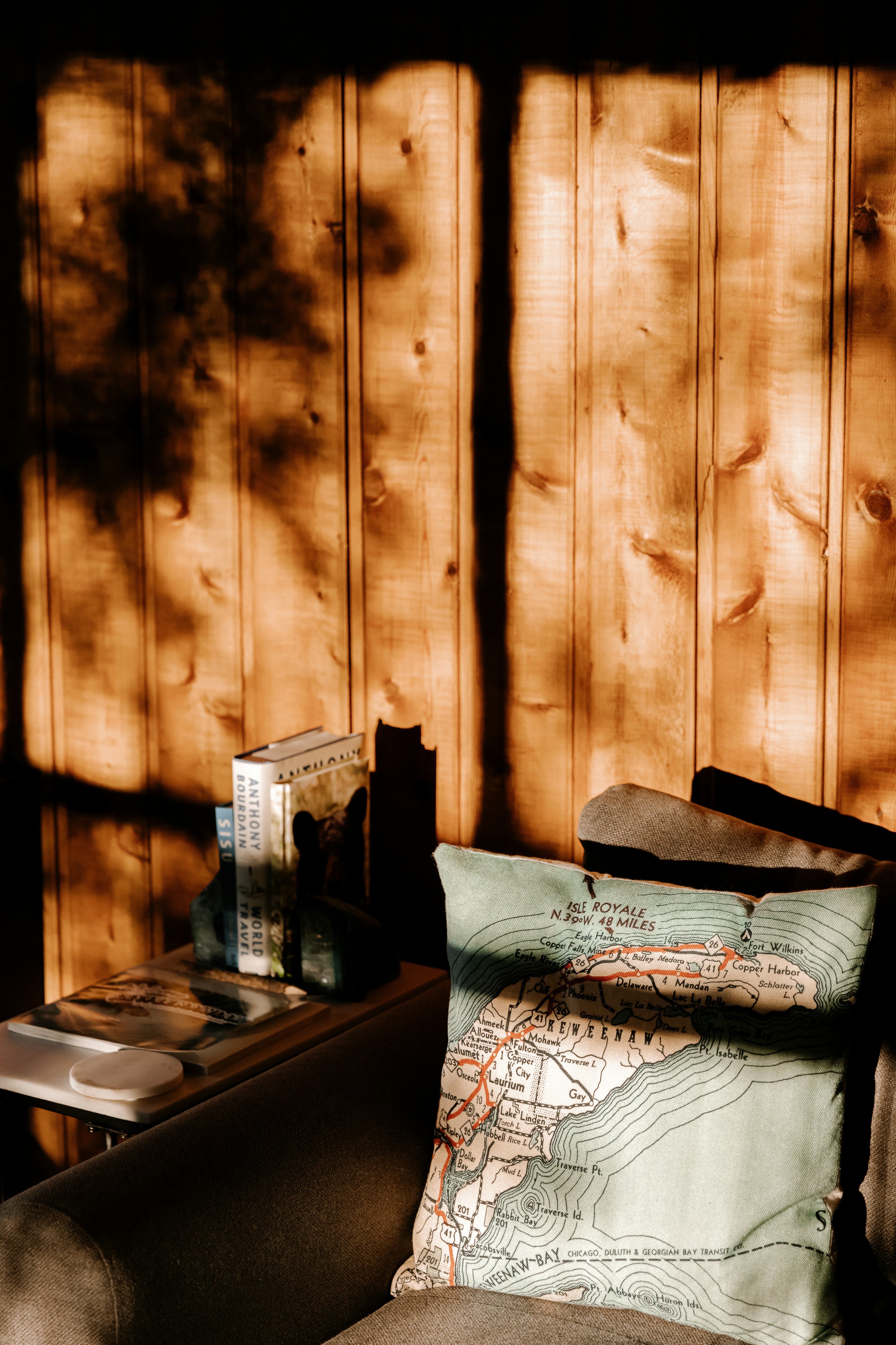 a couch with a map on it in front of a wooden wall