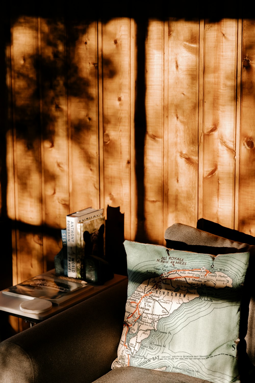 a couch with a map on it in front of a wooden wall