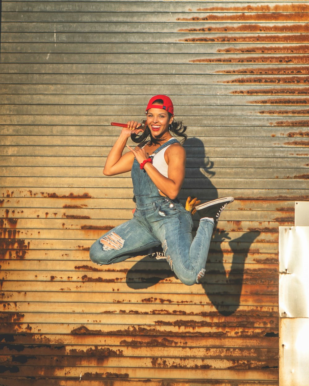 a woman jumping in the air with a skateboard