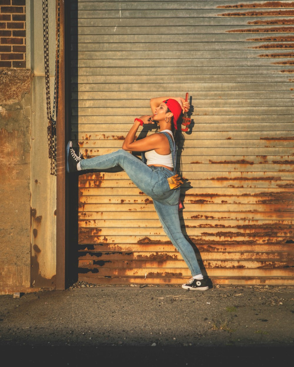 a woman leaning up against a garage door