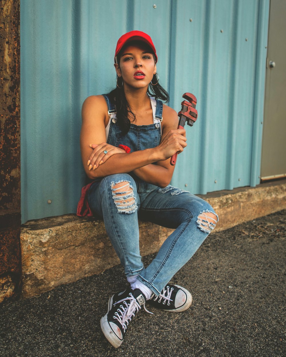 a woman sitting on the ground with a baseball bat