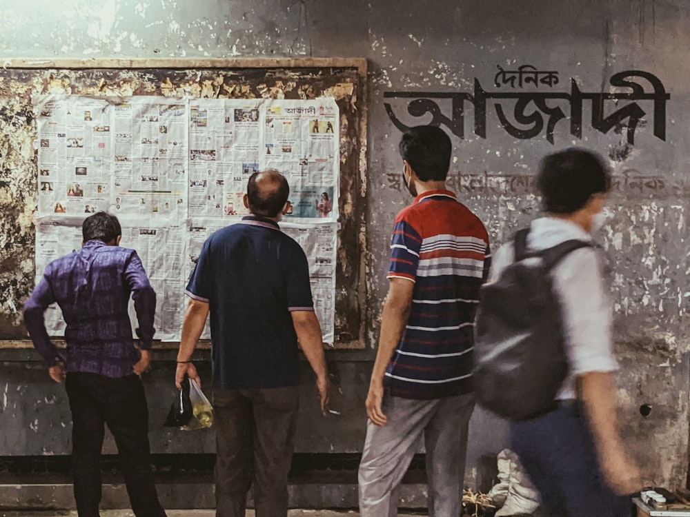 a group of people standing in front of a bulletin board