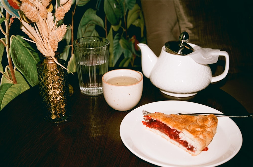 a piece of pie on a plate next to a cup of tea