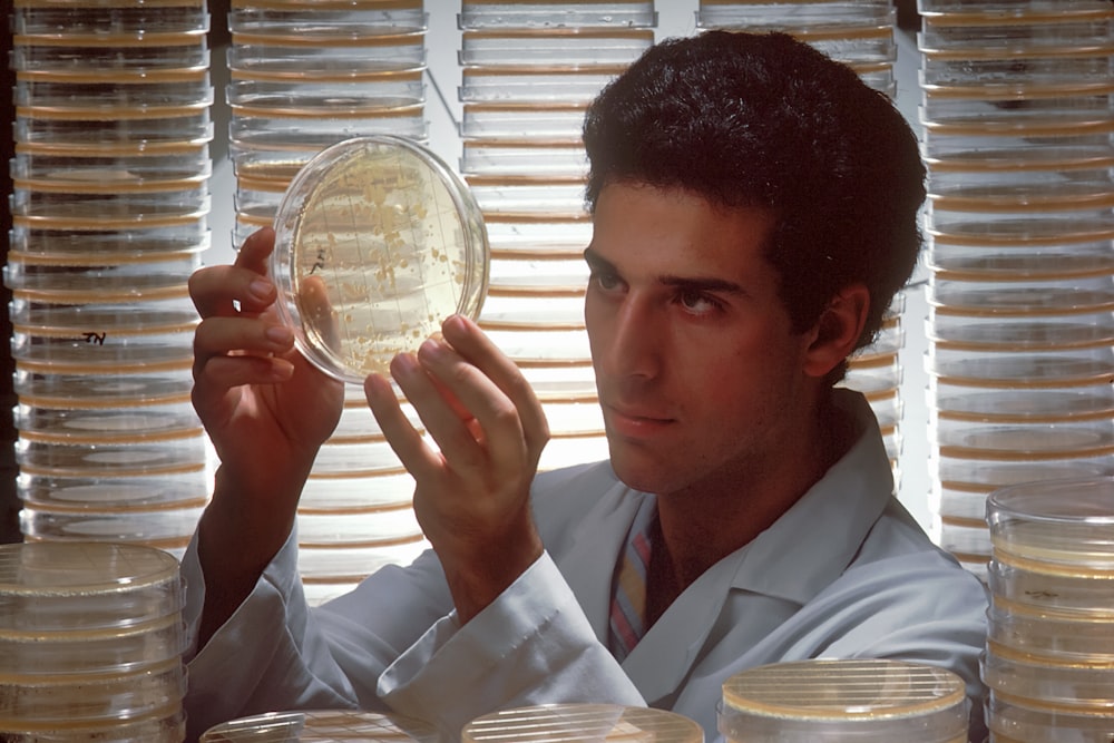 a man in a lab coat holding up a plate