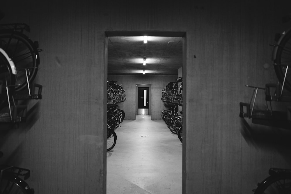 a black and white photo of a hallway with bikes