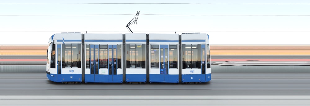 a blue and white bus traveling down a street