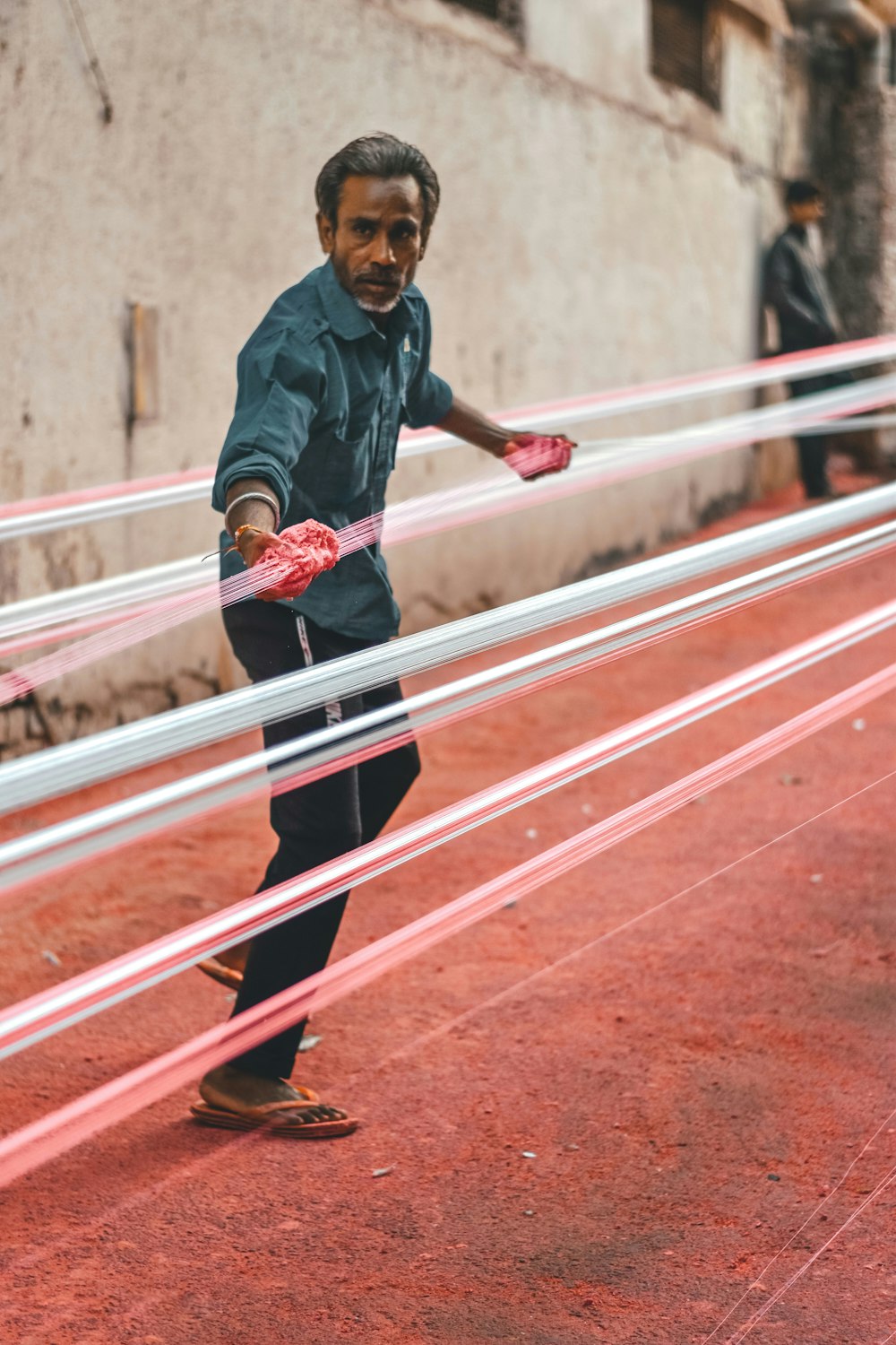 a man holding a pair of pink gloves