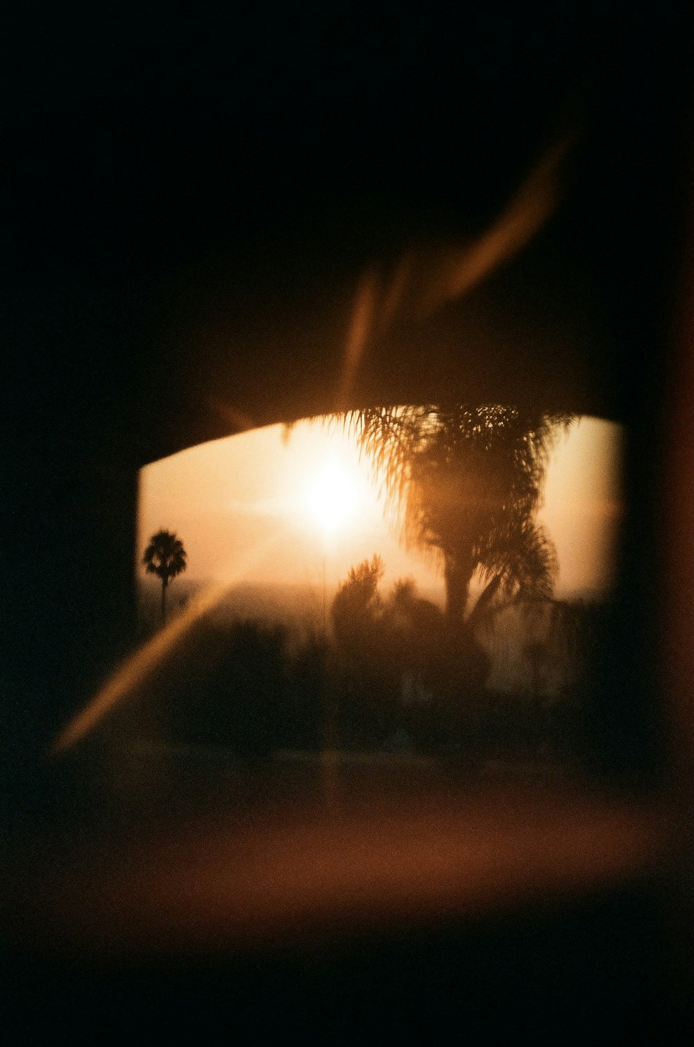 Un tramonto visto attraverso lo specchietto retrovisore di un'auto