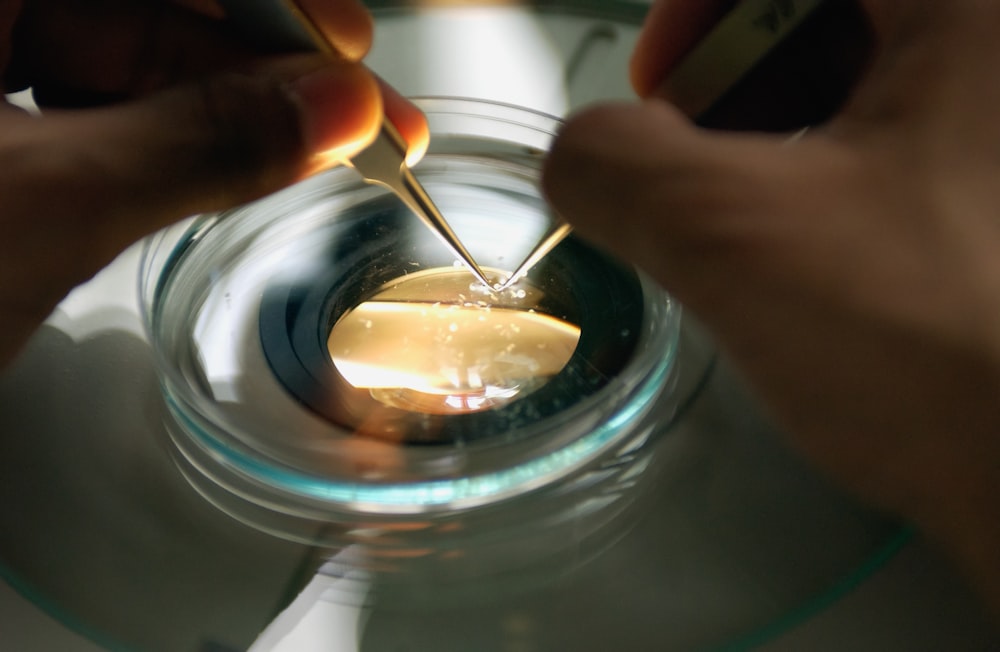 a person holding a spoon in a glass bowl