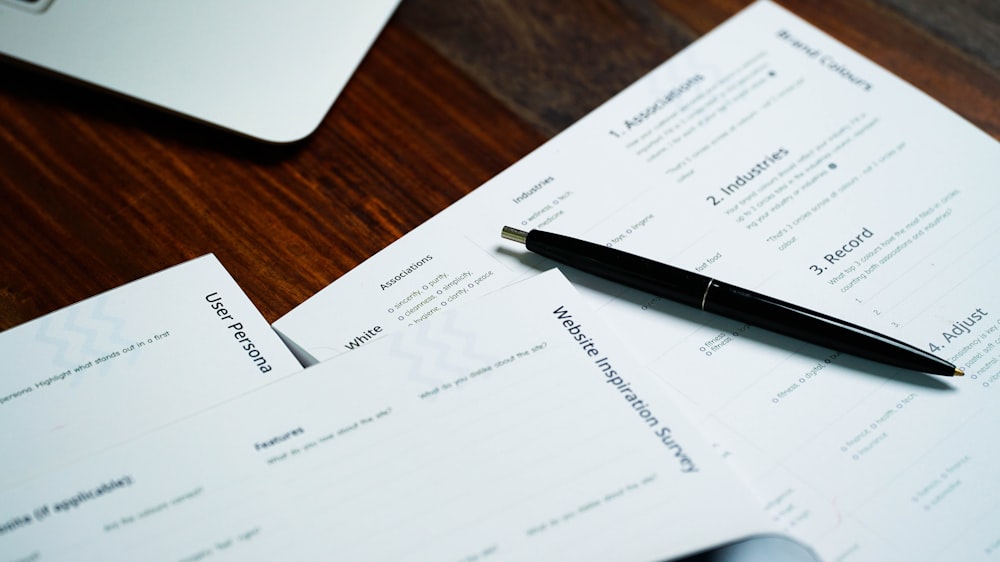 a pen sitting on top of a pile of papers