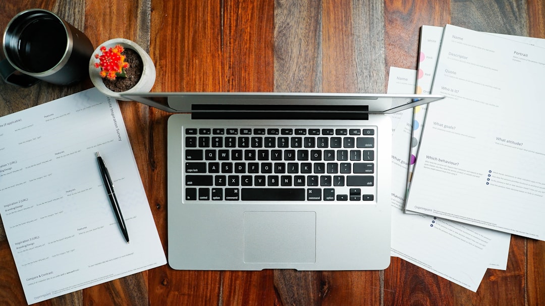 a laptop computer sitting on top of a wooden desk,