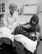 a black and white photo of a woman in a doctor's office with a