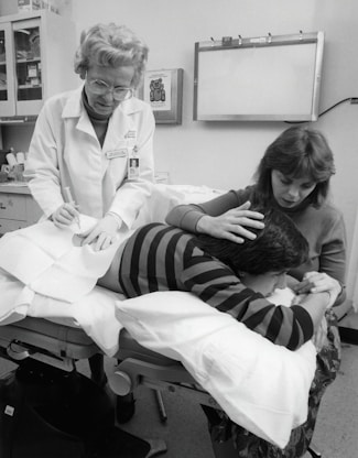 a black and white photo of a woman in a doctor's office with a