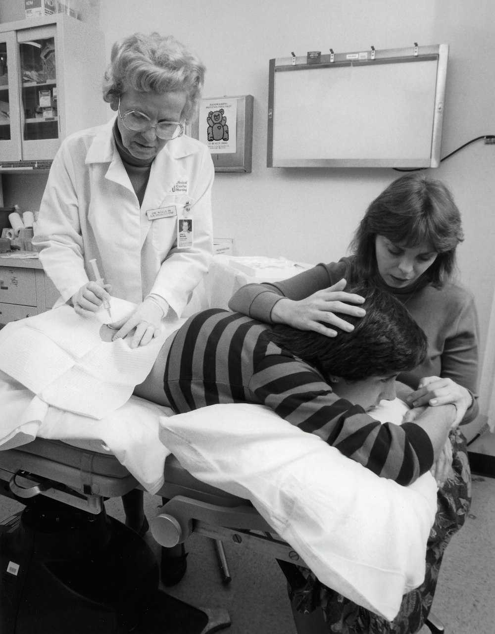 uma foto em preto e branco de uma mulher em um consultório médico com um