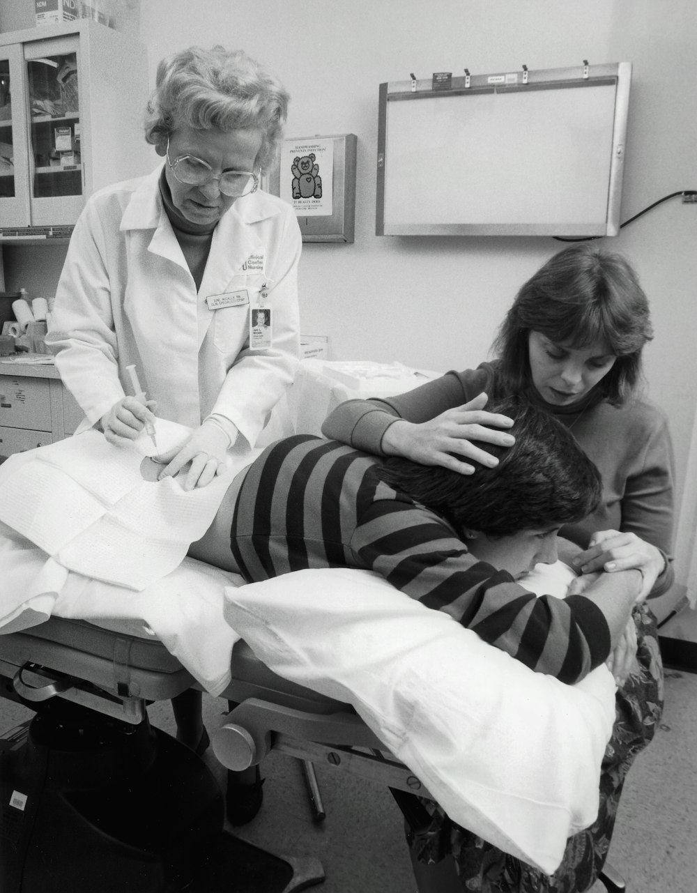 a black and white photo of a woman in a doctor's office with a