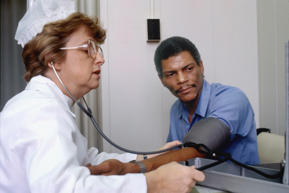 Ein Arzt, der einem Patienten mit einem Stethoskop zuhört