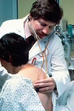 a doctor examining a woman's chest with a stethoscope