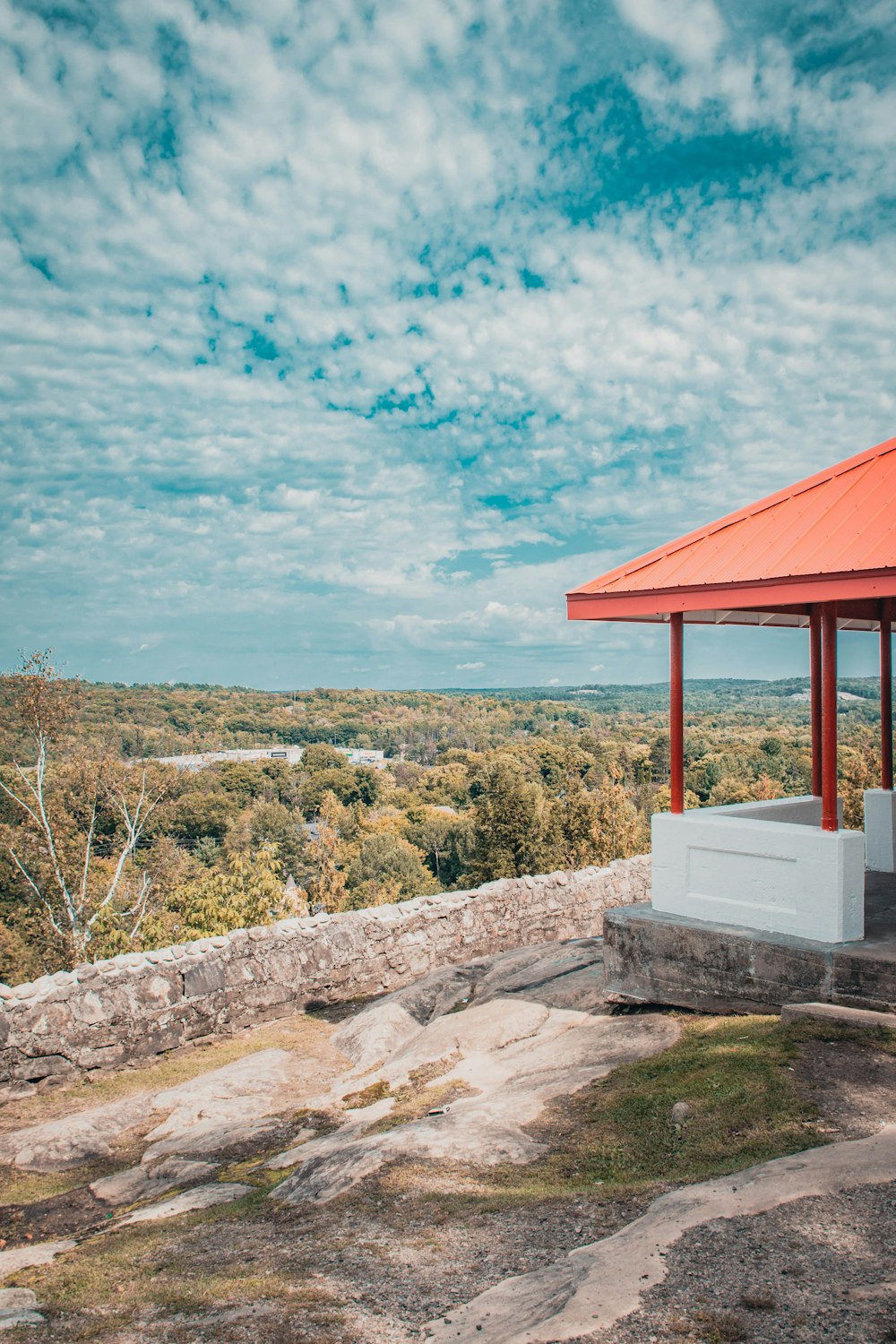 a gazebo on top of a hill with trees in the background