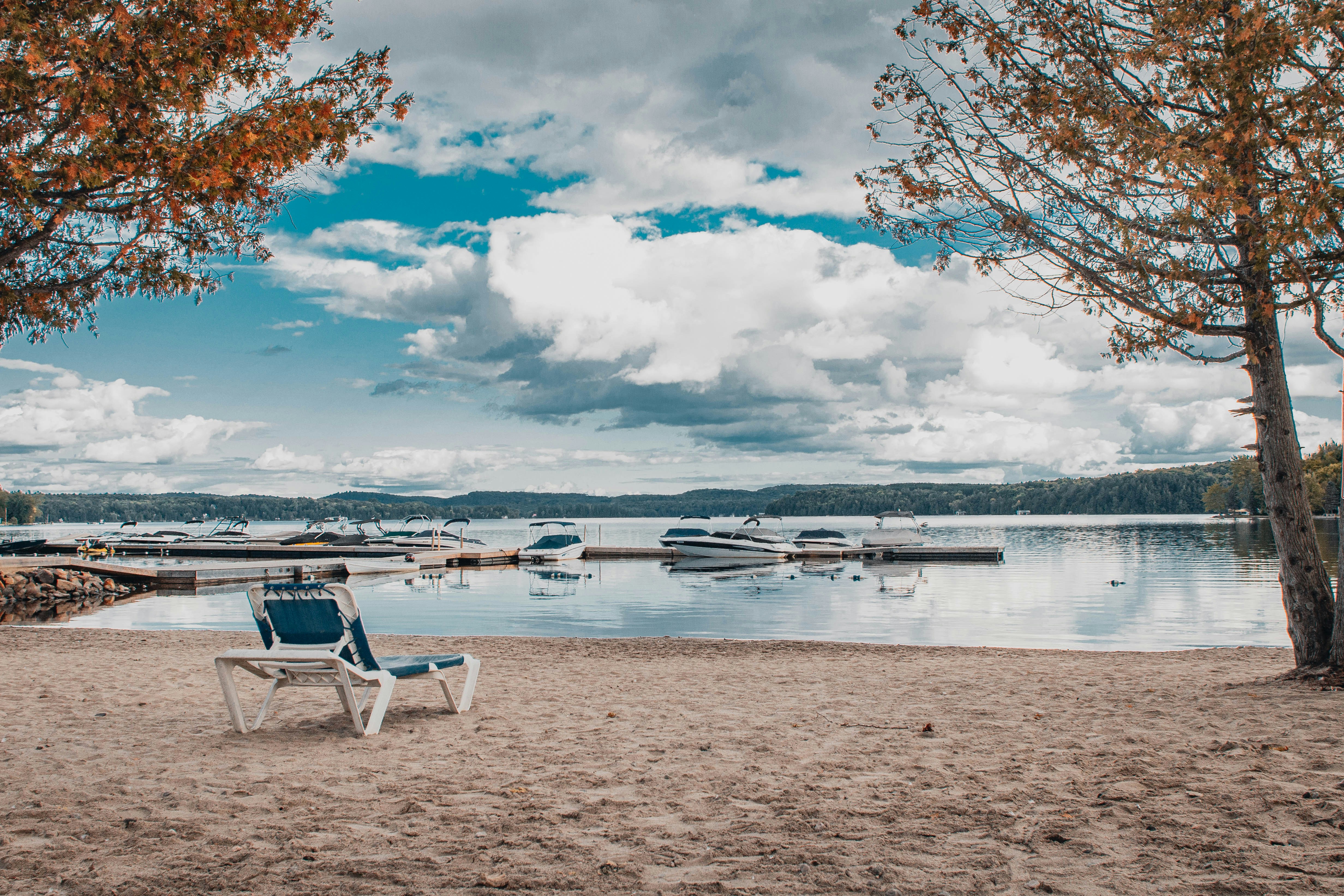 a chair sitting on a beach next to a body of water, 