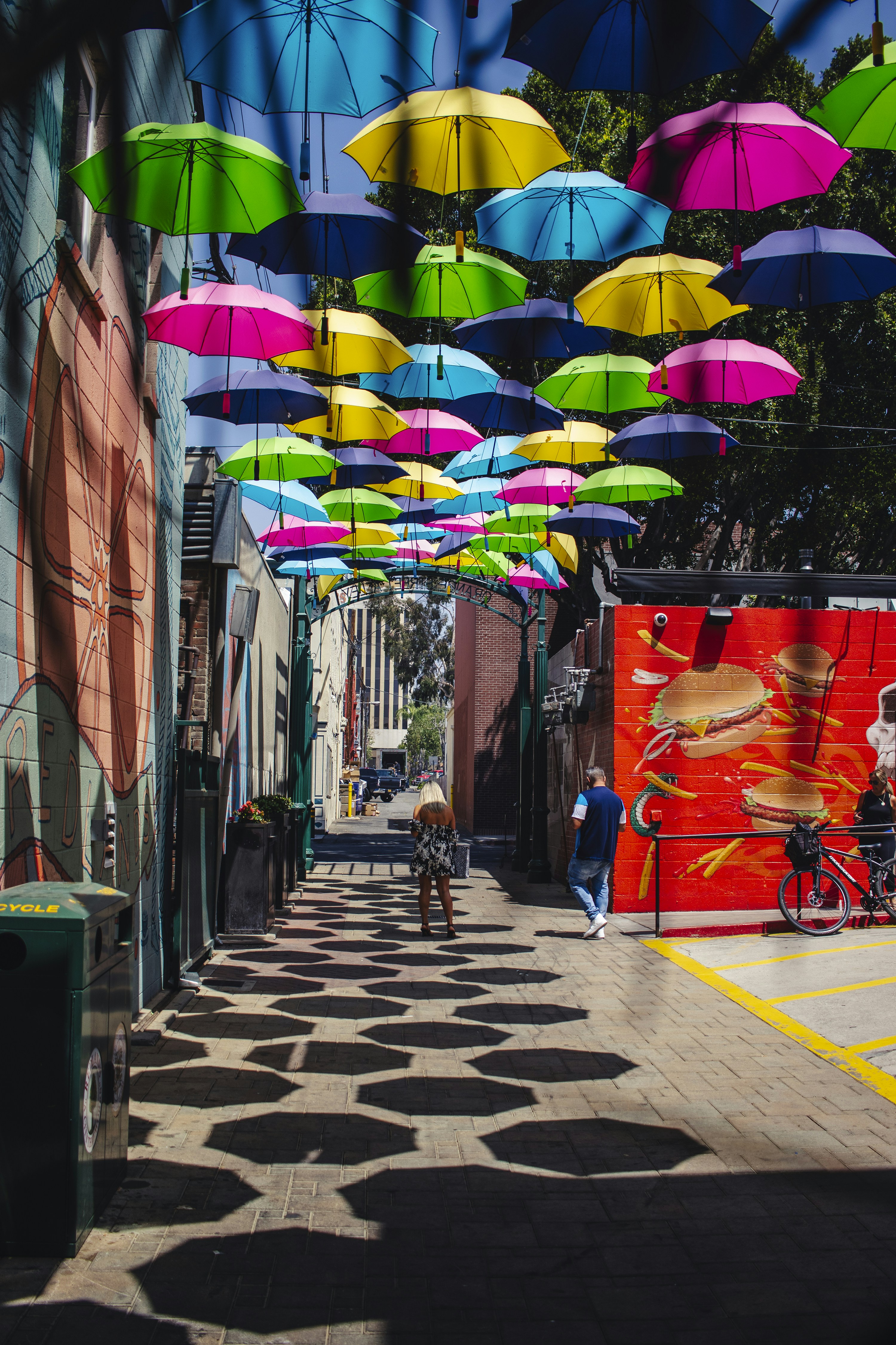 a group of umbrellas hanging from the ceiling of a street