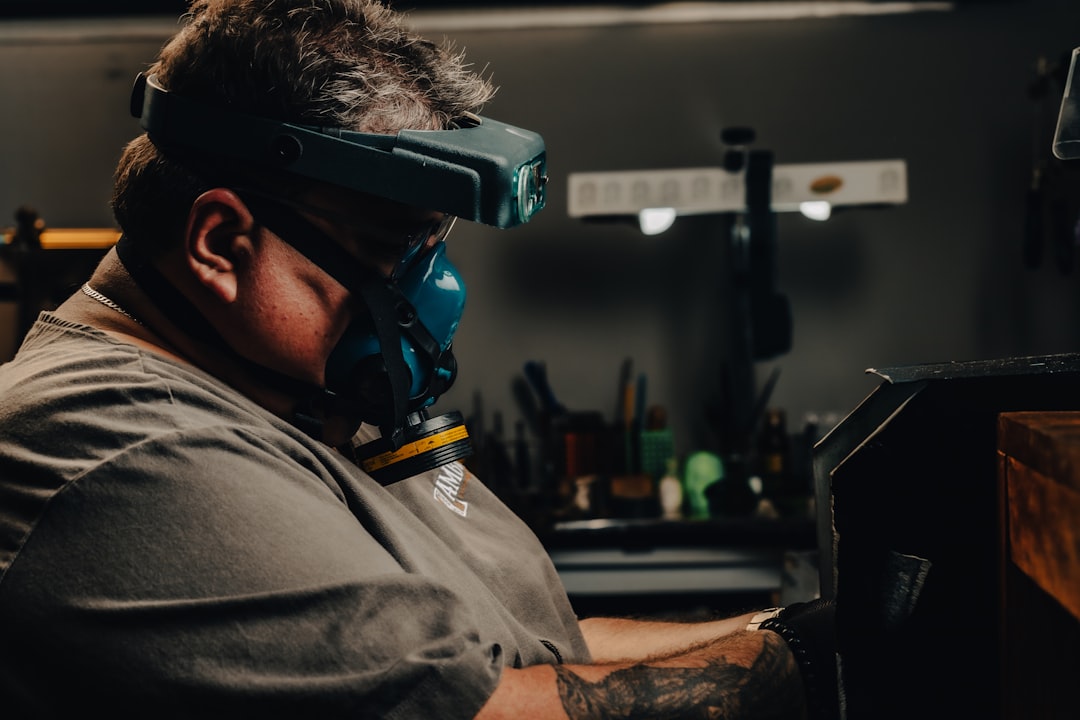 a man wearing a goggles while working on a piece of furniture,