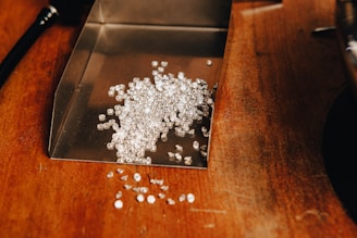 a pile of white beads sitting on top of a wooden table