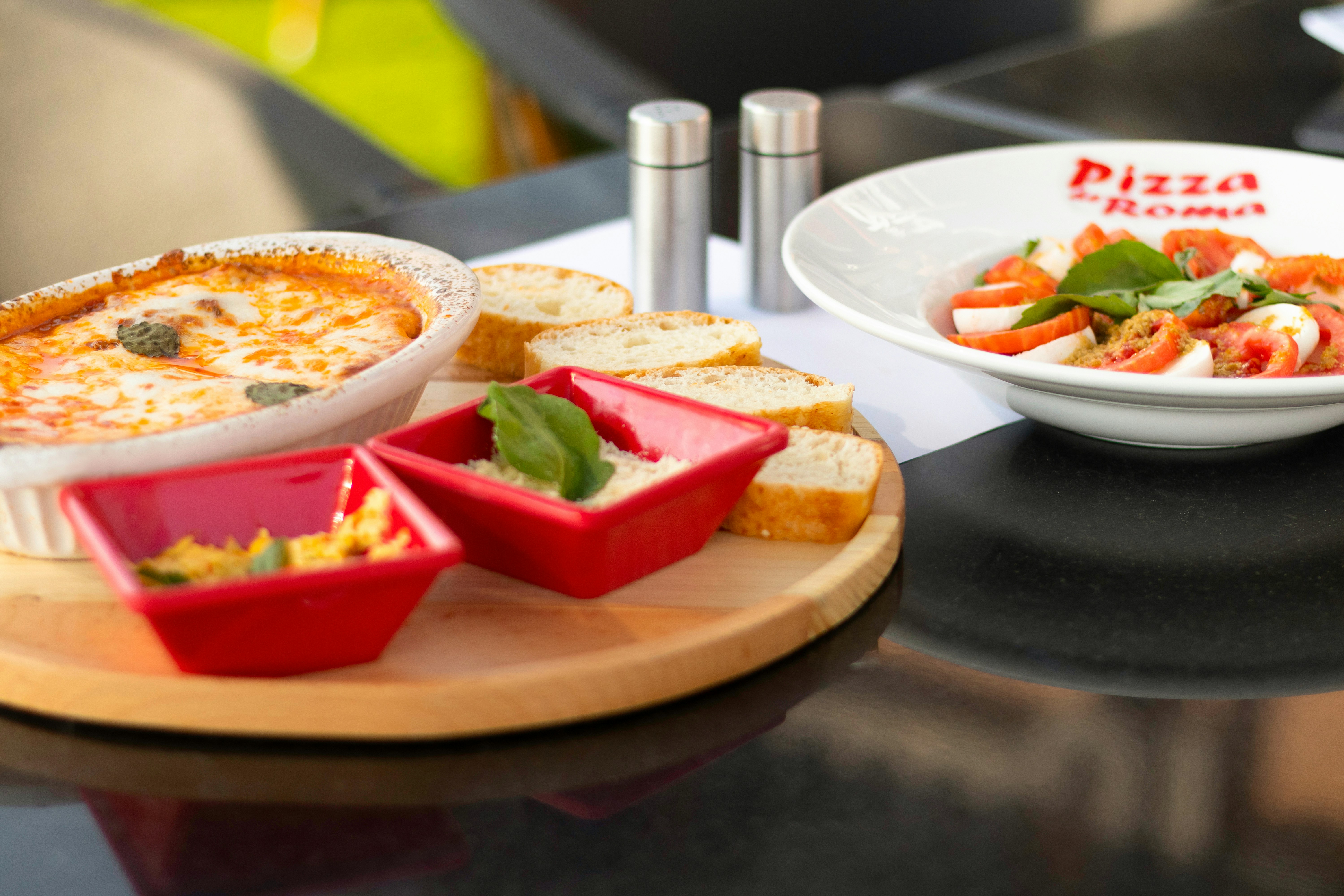 テーブルの上のピザのプレートとサラダのボウル