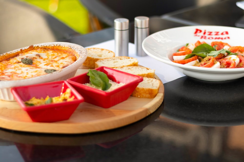 a plate of pizza and a bowl of salad on a table