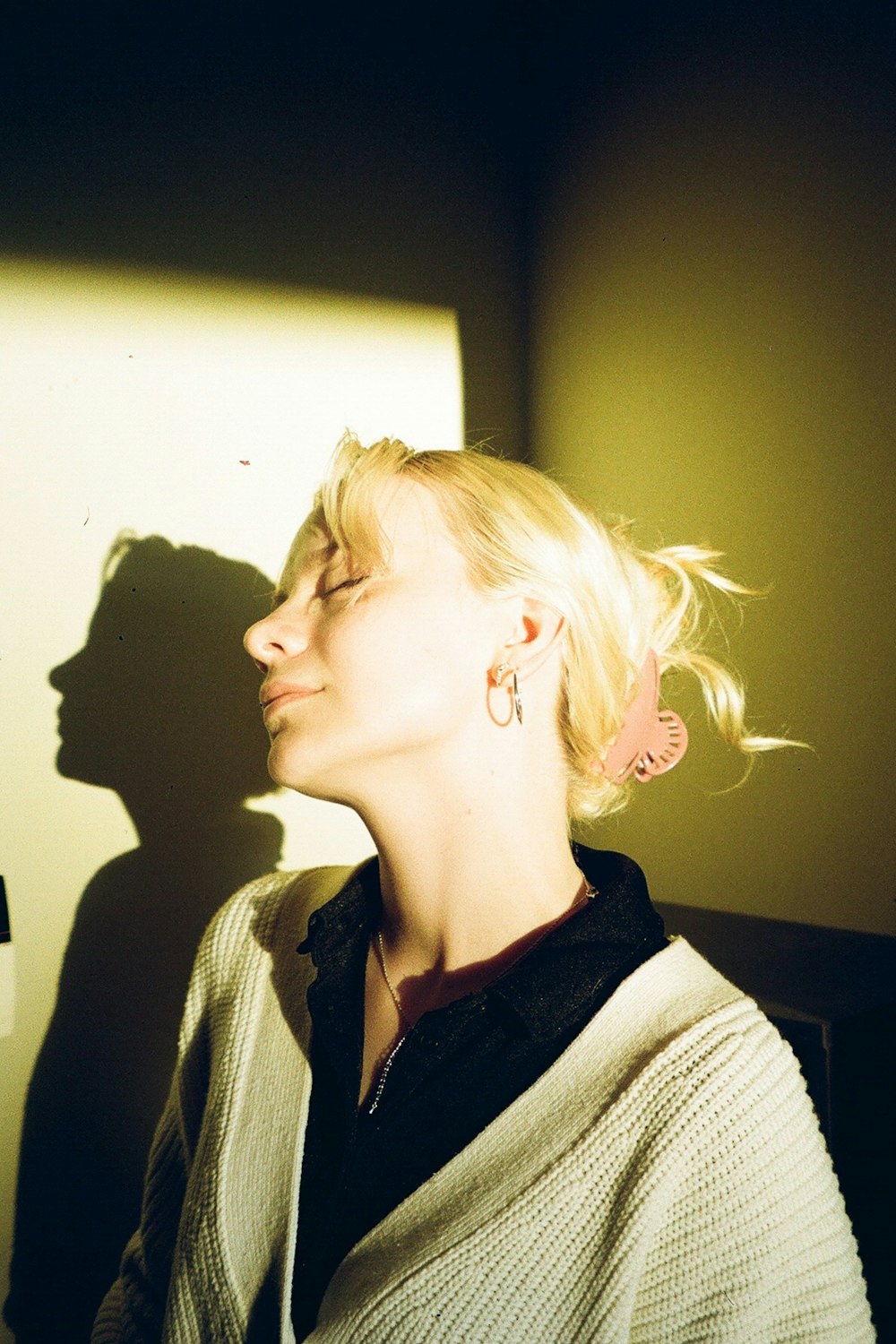 a woman with her eyes closed standing in a room