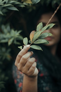 a woman holding a plant in her hand