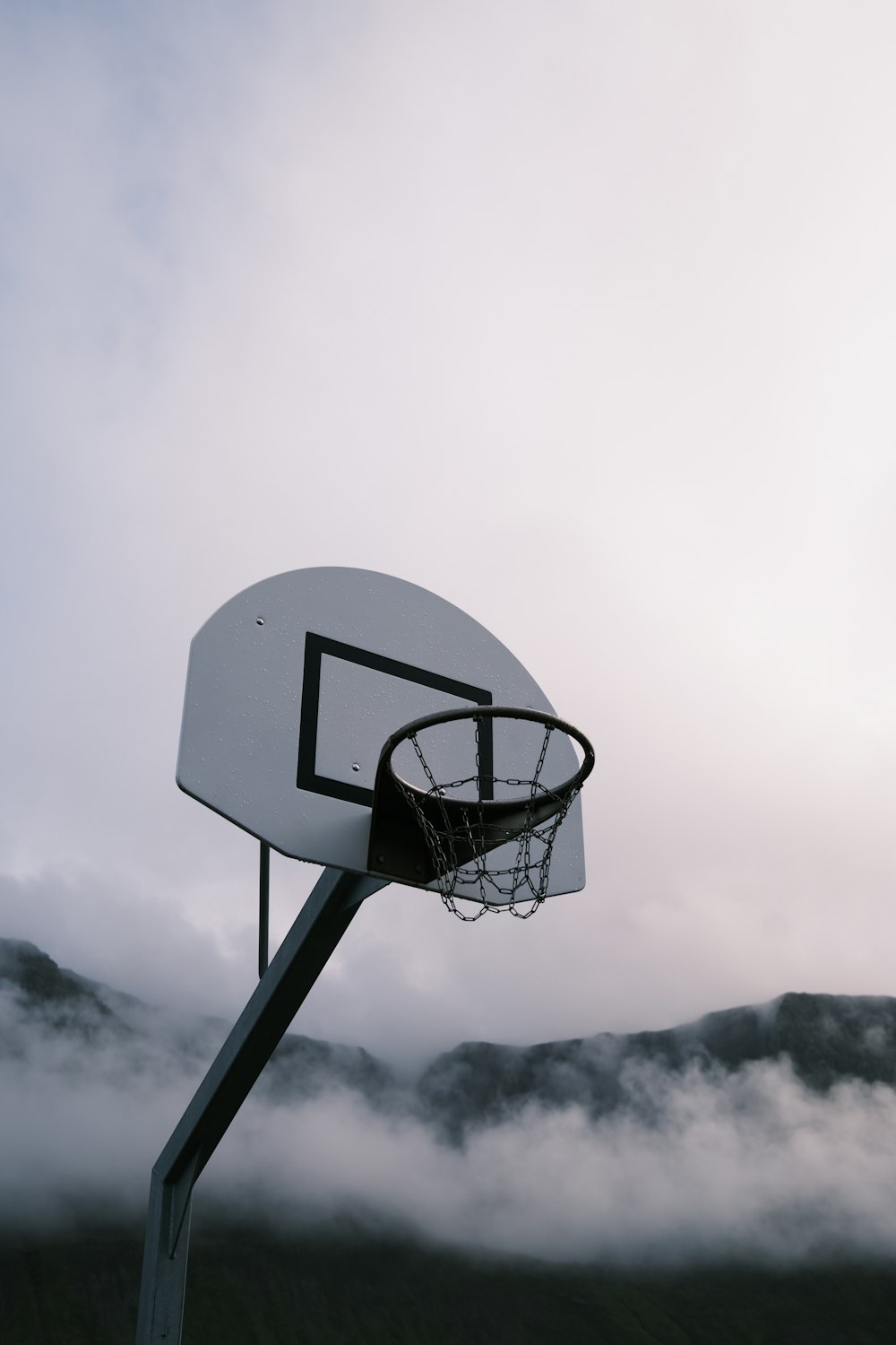 a basketball hoop in the middle of a foggy field