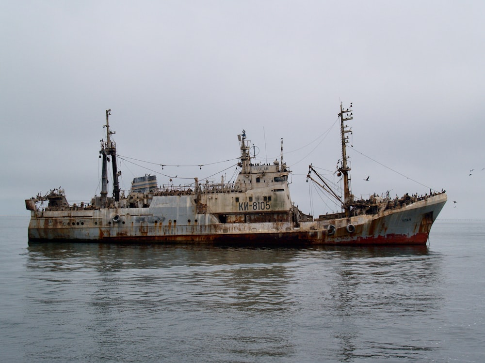 an old rusted ship in the middle of the ocean