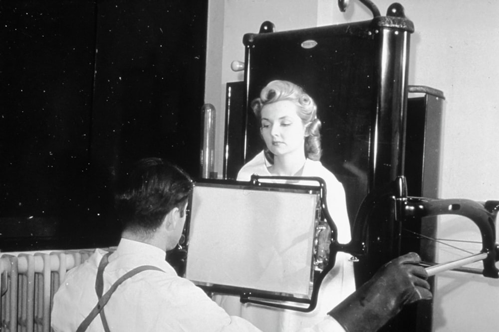 a woman sitting in a chair looking at a mirror