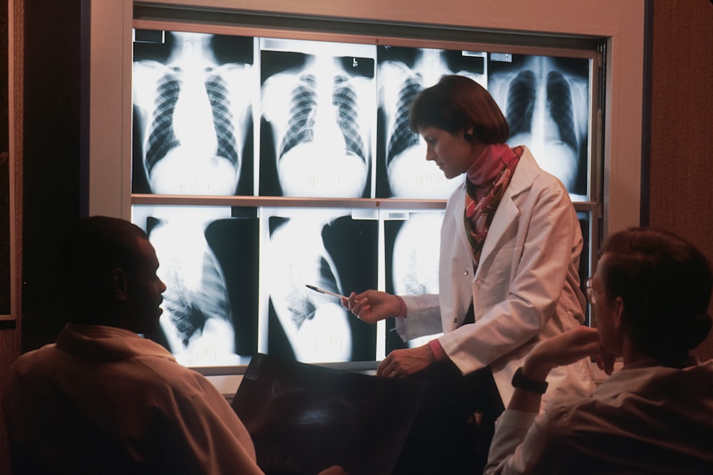 um médico conversando com um paciente na frente de um raio-x