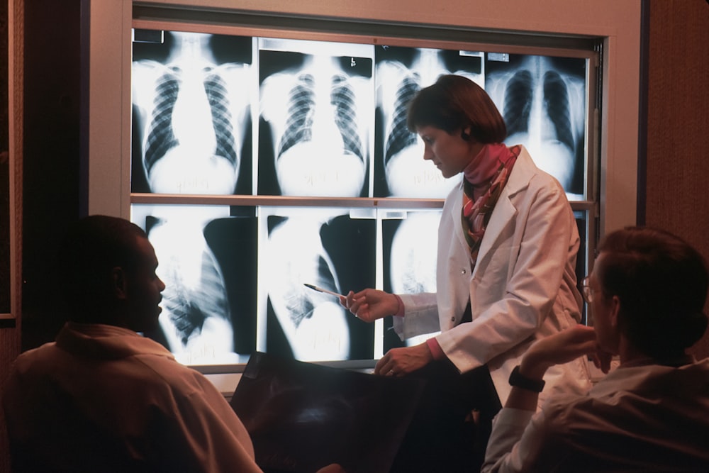 a doctor talking to a patient in front of a x - ray